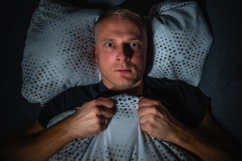 Hombre se despierta de una pesadilla.