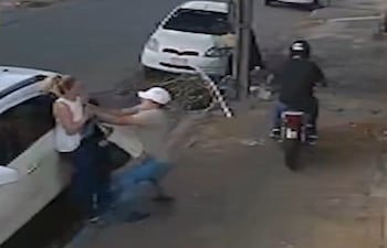 Momento en el que uno de los asaltantes intenta despojar a la mujer de su celular. El conductor de la moto fallecería después.