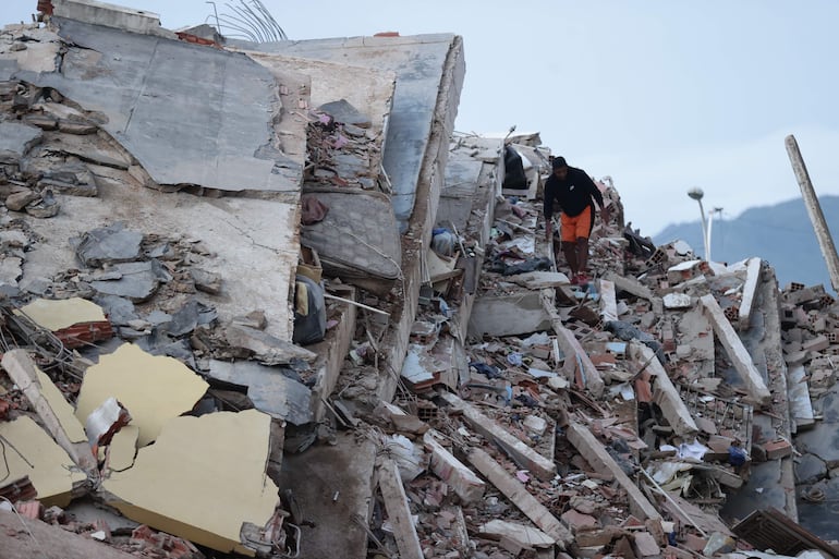 Un residente entre los escombros de un edificio derrumbado a consecuencia de los terremotos, en la localidad de Catia La Mar, en el estado costero de La Guaira (Venezuela) este jueves. 
