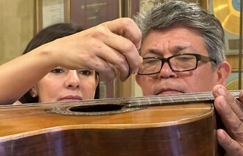 Luz y Aníbal Borja observan los detalles de la guitarra José Ramírez (1911) que perteneció al compositor paraguayo Agustín Pío Barrios (Mangoré).