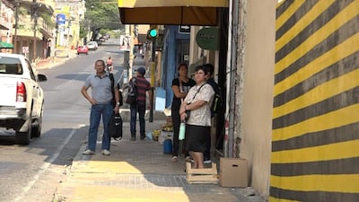 Personas se refugian del calor bajo los toldos de los comercios ubicados en el microcentro de Asunción.
