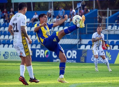 Intento de despeje de Giovanni Bogado ante Gustavo Viera, en el partido de la primera rueda del Clausura 2026, celebrado en el 12 de Octubre de Itauguá, con triunfo de Trinidense sobre Luqueño por 4-1.