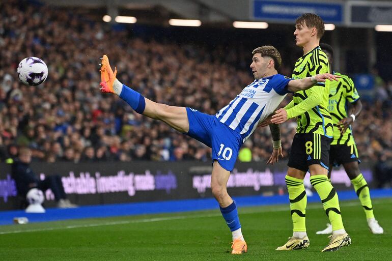 El paraguayo Julio Enciso (i), futbolista del Brighton, pelea por el balón en un partido frente al Arsenal por la Premier League de Inglaterra.