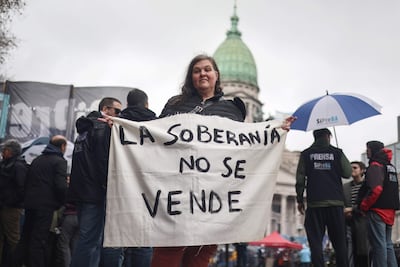 Una mujer sostiene un cartel en una manifestación contra un proyecto de ley impulsado por el Gobierno del ultraliberal Javier Milei que introduce cambios en los procesos de desalojo, expropiaciones y uso de tierras quemadas, este jueves en Buenos Aires.