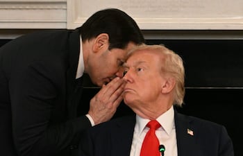 El secretario de Estado estadounidense, Marco Rubio, entrega un informe al mandatario Donald Trump. La imagen fue seleccionada como una de las fotos destacadas de 2025.