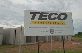 Cartel de obra de TECO constructora en el terreno donde permanecen abandonadas las estructuras de hormigó que deberían ser utilizadas para la abandonada obra.