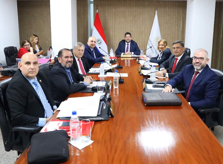 Gerardo Bobadilla al centro en traje formal, rodeado de miembros del Consejo de la Magistratura en ambiente profesional.