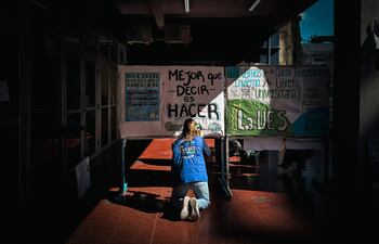 Una mujer pintando un cartel en la Facultad de Ciencias Sociales de la UBA, en Buenos Aires (Argentina). El Senado argentino aprobó en la madrugada de este viernes el proyecto de ley de financiación de la educación universitaria, en medio de las protestas de los docentes y personal del sector y bajo la amenaza de veto del presidente, Javier Milei.