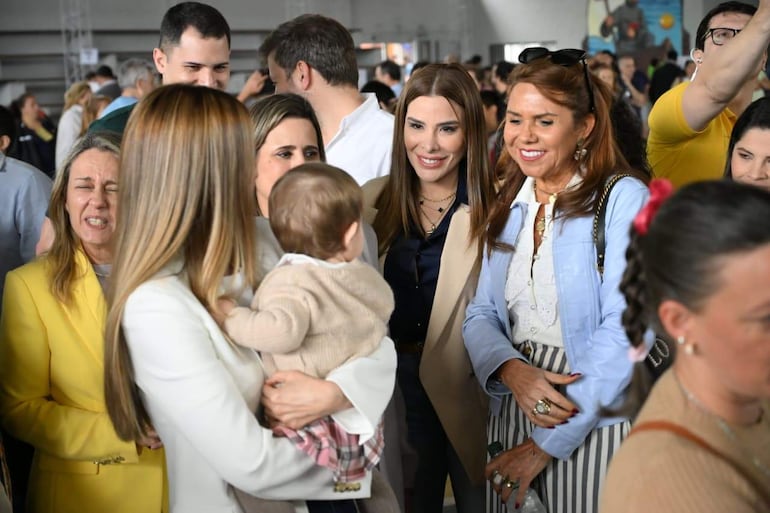 Soledad Núñez sonríe mientras conversa con Bruno Defelippe, rodeados de otras personas en un ambiente animado.