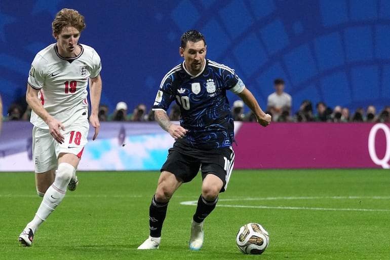 Anthony Gordon (i) de Inglaterra disputa el balón con Lionel Messi de Argentina este miércoles, en el partido de semifinales del Mundial de la FIFA 2026 entre Inglaterra y Argentina en el estadio Mercedes-Benz en Atlanta (Estados Unidos).