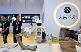 Un robot fabricado por Molaibuyuan dobla ropa durante la Conferencia Mundial de Robótica 2026, en Pekín, el 19 de agosto de 2026.