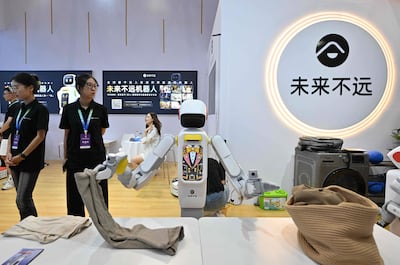 Un robot fabricado por Molaibuyuan dobla ropa durante la Conferencia Mundial de Robótica 2026, en Pekín, el 19 de agosto de 2026.