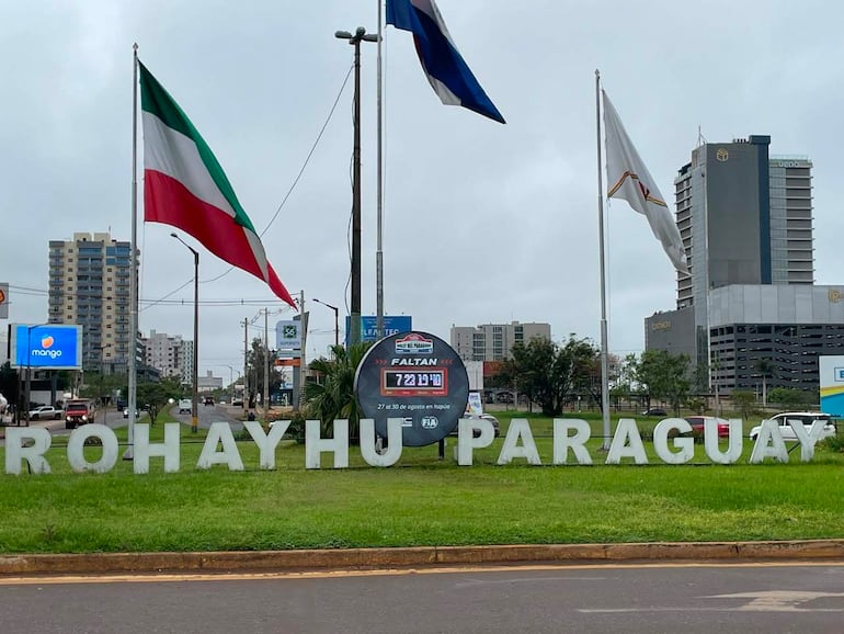 Señal de bienvenida 'ROHAYHU PARAGUAY' con banderas y un conteo regresivo para el Mundial de Rally en un entorno urbano.
