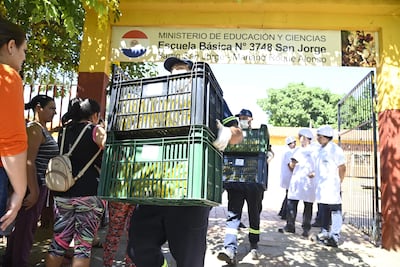 Funcionarios de Comepar retiran las bananas de la escuela San Jorge, que debían ser repartidas luego del guiso de carne de cerdo.