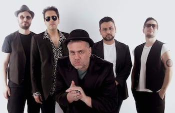 Cinco miembros de Blues del Sur posan en un fondo blanco, vestidos informalmente, con gafas de sol y un sombrero al frente.