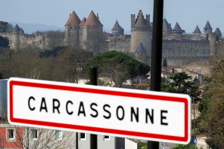 Letrero de entrada a la ciudad de Carcasona, en Francia, con la ciudadela medieval al fondo