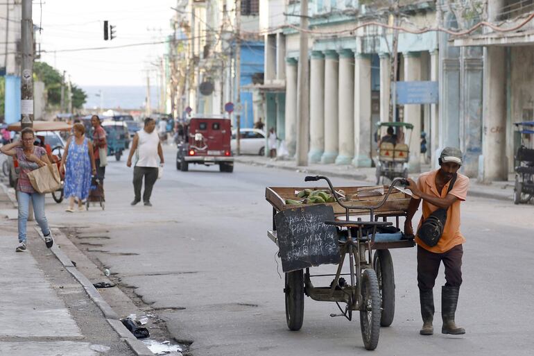Un hombre transporta una carretilla con plátanos, en La Habana (Cuba).
