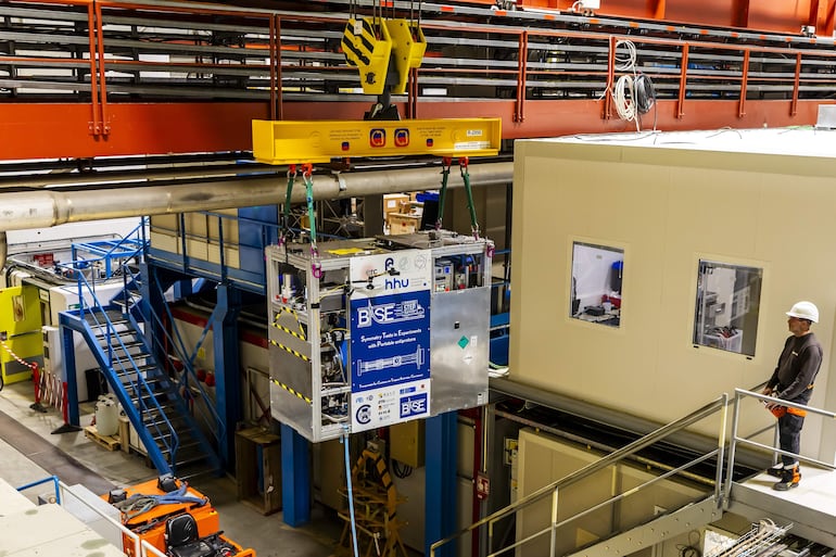 Técnicos trasladan una trampa de antimateria transportable al Antimatter Factory del CERN en Meyrin, cerca de Ginebra, el 24 de marzo de 2026, antes de una prueba en carretera en la que los científicos transportaron antimateria en camión por primera vez. La trampa mide 2 metros de largo, 1,58 metros de alto y 0,87 metros de ancho, y pesa aproximadamente una tonelada.