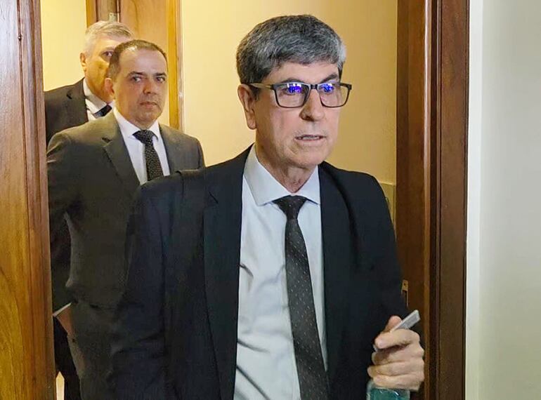  El abogado Alcides Cáceres se retira del juzgado, seguido de John Gerald Matthias Gaona, directivo de Zeta Banco.