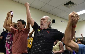 Víctimas de la tortura Luis Casco y Carlos Casco celebran la sentencia del comisario de policía retirado Eusebio Torres por la tortura de víctimas de la dictadura del general Alfredo Stroessner (1954-1989) en el Palacio de Justicia de Asunción en febrero 20 de septiembre de 2024. El comisario de policía retirado Eusebio Torres Romero fue sentenciado a 30 años de prisión por torturar a dos hermanos y a la esposa de uno de ellos durante la dictadura del general Alfredo Stroessner en Paraguay, según un fallo judicial publicado el martes. (Foto de NORBERTO DUARTE/AFP)