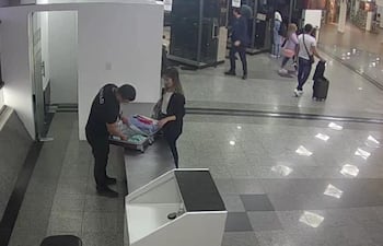 A las 16:35 el agente de la SENAD procede a la apertura y verificación de la maleta de Eliana Cardozo y al abrir uno de los compartimientos visualiza un envoltorio de tela color azul con varios paquetes rectangulares de cocaína.
