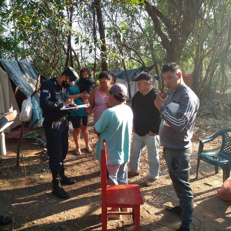 Un efectivo policial toma apunte de los ocupantes de la propiedad fiscal, que la comuna dice que es para parque industrial.
