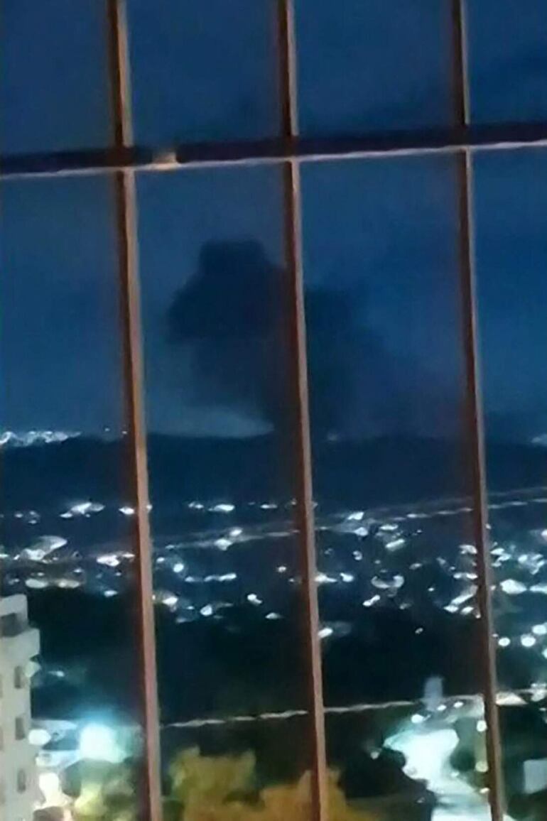 Esta imagen, tomada el 3 de enero de 2026, de un video de UGC, muestra una columna de humo sobre Caracas tras una serie de explosiones. 