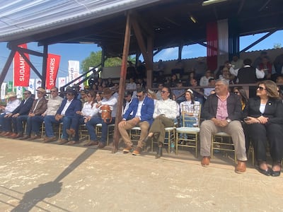 Asistentes en Expo Concepción 2026, vestidos mayormente de blanco, lucen expresiones de tranquilidad y alegría entre banderas decorativas.