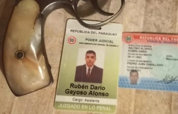 El arma de fuego y las credenciales de Rubén Darío Gayoso Alonso, imputado por la Fiscalía.
