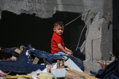 Un niño sentado sobre escombros de una vivienda destruida por un bombardeo israelí en Al-Bureij, en la zona central de la Franja de Gaza, este martes.
