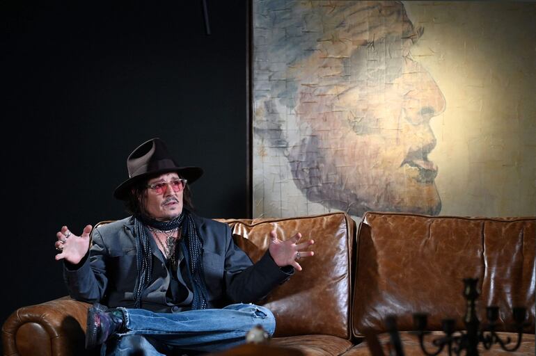 Johnny Depp habla frente a una de sus pinturas durante una entrevista después de una vista previa para los medios de su exposición de arte titulada "A Bunch of Stuff" en Tokio. (GREG BAKER / AFP)