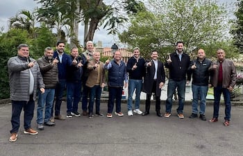 Mario Abdo Benítez y otros hombres se reúnen al aire libre, todos levantan un dedo índice, con expresiones felices y vestimenta casual.