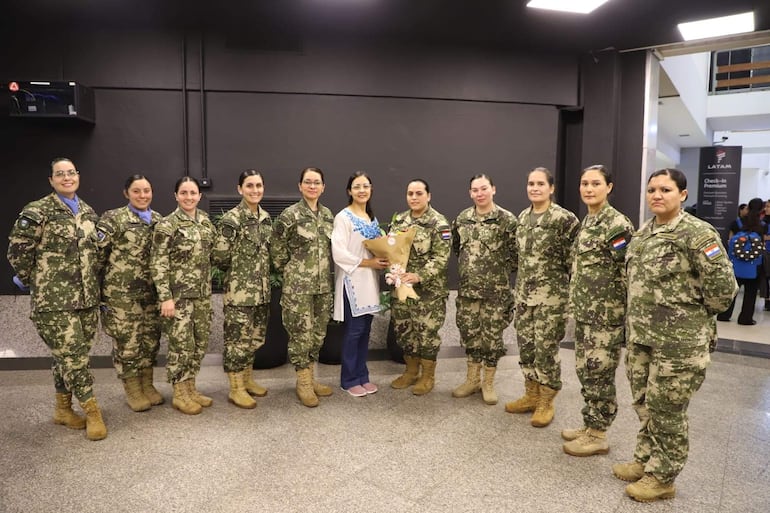 María Eugenia Alonso Iglesias, capitán de aviación, es la primera persona paraguaya y mujer en ir misión de paz a India Pakistán como observadora en el ejército de los cascos azules de las Naciones Unidas. Aquí rodeada de militares camaradas y superiores en el Aeropuerto Internacional antes de su viaje.
