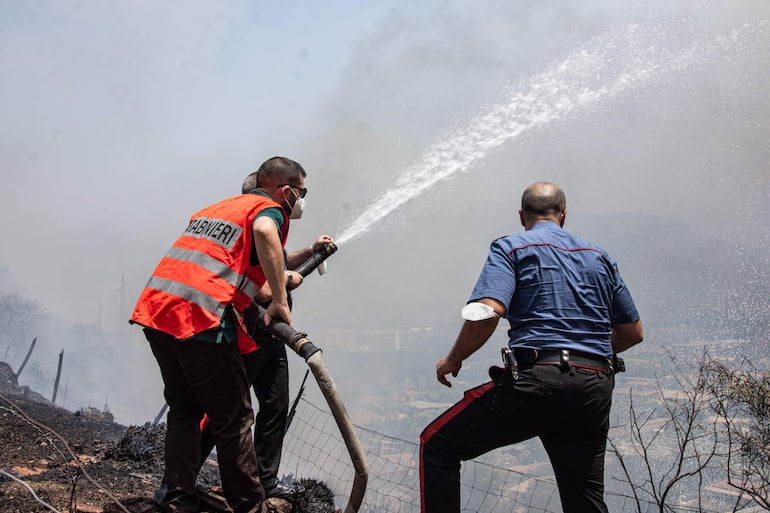 Palermo (Italia), 25/07/2023.- Agentes de policía ayudan a los lugareños a apagar un incendio forestal que se acerca a casas en Palermo, Sicilia, sur de Italia, el 25 de julio de 2023. Los incendios forestales han arrasado Sicilia en medio de la última ola de calor de Italia y el aeropuerto de Palermo estuvo cerrado brevemente al tráfico en la mañana del 25 de julio.