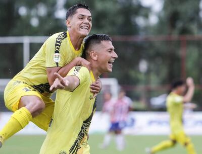 El extremo recoletano Héctor López (18 años) se trepa por Lucas González (26), quien se encargó de anotar el tanto del primer triunfo “Canario”, ayer en el estadio Municipal de Carapeguá. (Foto: APF)