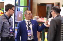 Ignacio Cano (C), CEO de Comercial Virgen del Rosario, conversa con otros visitantes en la feria.