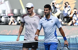El italiano Jannik Sinner (i) y el serbio Novak Djokovic al finalizar la primera semifinal del Abierto de Australia 2024 en Melbourne, Australia.