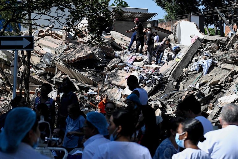 Personas trabajan en un edificio colapsado tras un terremoto en Cali, Colombia, el 10 de agosto de 2026. Un fuerte sismo sacudió Colombia y países vecinos de América Latina; equipos médicos acudieron rápidamente a asistir a las víctimas después de que varios edificios sufrieran daños o colapsaran en distintas ciudades. 