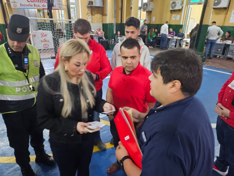 La fiscala Sandra Ledesma, acompañada de policías, verifica la situación y la información insertada en los documentos de cuya falsedad se sospecha.