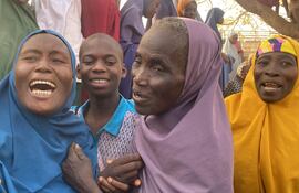 Las mujeres reaccionan cuando los niños, que fueron liberados después de ser secuestrados por hombres armados en Kuriga, se reúnen con sus familias en Kuriga.