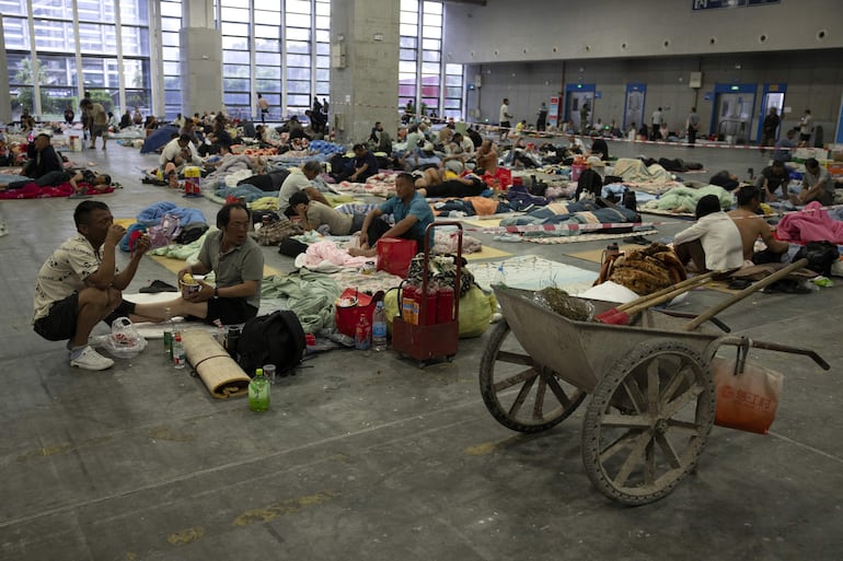 Trabajadores descansan en un refugio instalado antes del paso del tifón Bavi, en Wenzhou, provincia de Zhejiang, este de China, 11 de julio de 2026.