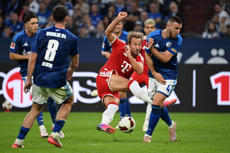 El delantero inglés del Bayern Múnich Harry Kane (C) intenta un disparo ante el defensa turco del Schalke 04 Hasan Kurucay (D) durante el partido de fútbol de la primera división alemana de la Bundesliga entre el Schalke 04 y el FC Bayern Múnich en Gelsenkirchen, en el oeste de Alemania.