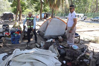 Integrantes de equipos de protección civil, retiran este jueves un campamento de migrantes en la ciudad de Tapachula en Chiapas (México).
