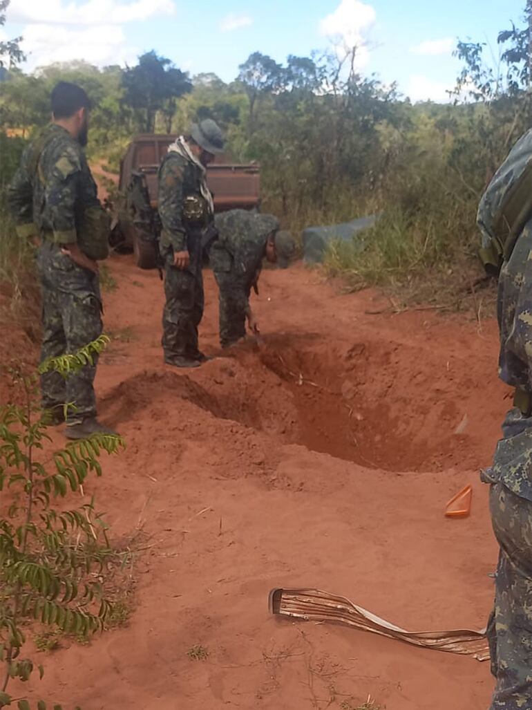 Militares revisan el lugar donde estaba enterrada la bomba.