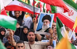 Un hombre con un retrato del ayatolá Alí Jameneí, líder supremo de Irán, durante una celebración del alto al fuego en el conflicto con Israel, ayer martes en Teherán.