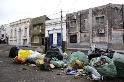 Entorno urbano con acumulación de basura y veredas rotas en Asunción, sin personas visibles en la escena.