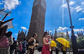 Varias personas pasean por Londres, este lunes. El Reino Unido, especialmente Londres y las afueras de la capital, espera este lunes temperaturas en torno a los 34 grados Celsius y el mes de junio más caluroso registrado hasta ahora, según los expertos en meteorología.