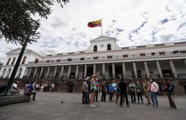 Ciudadanos ecuatorianos caminan a las afueras del Palacio de Gobierno en Quito (Ecuador).
