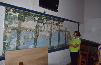 Profesora muestra la pizarra destrozada en un grado de la escuela.