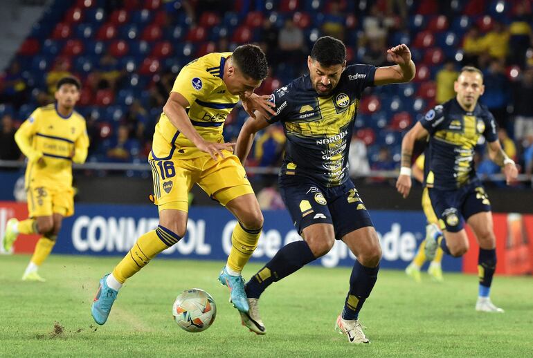 El paraguayo César Benítez (d), jugador del Sportivo Trinidense, pelea por el balón en un partido frente a Boca Juniors por la fase de grupos de la Copa Sudamericana 2024 en el estadio La Nueva Olla, en Asunción, Paraguay.